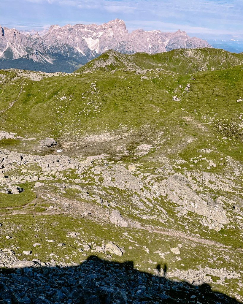 Schatten zweier Wanderer vor Bergkulisse 