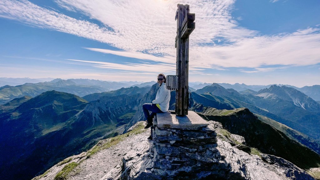 Person am Gipfelkreuz der Pfannspitze 